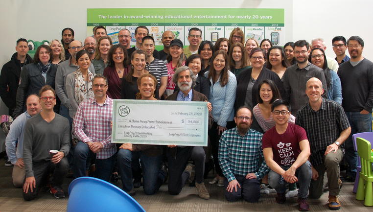 Group of people with $34,000 donation check from LeapFrog to Home Away from Homelessness Charity